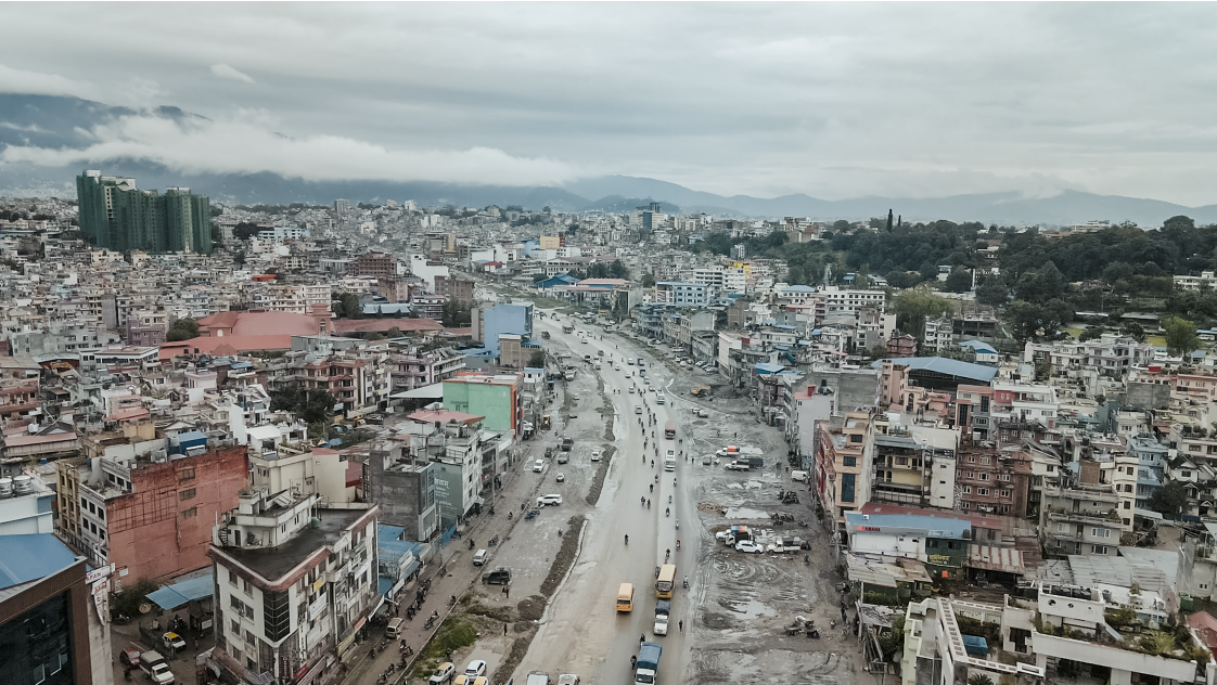 A photo of a main road in Kathmandu, with high rise buildings to either side.