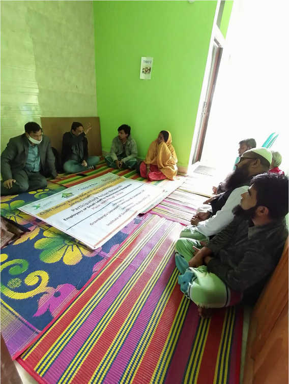 A photo of business owners at a meeting in Dhaka, sat on the floor in a circle, engaged in conversation