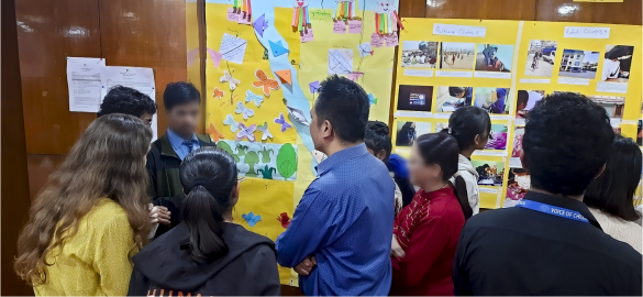 A photo of people standing by a gallery wall, engaged in conversation.