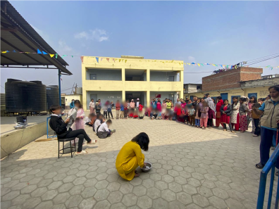 A photo of children performing a drama performance to an audience outside.