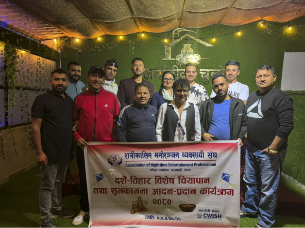 A photo of business owners in Nepal standing together, holding up an organisational banner